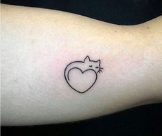 a cat with a heart tattoo on the arm