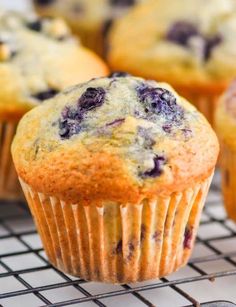 blueberry muffins on a cooling rack with other muffins in the background