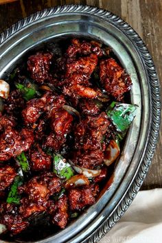 a metal bowl filled with meat and vegetables