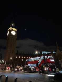 the big ben clock tower towering over the city of london at night with cars passing by