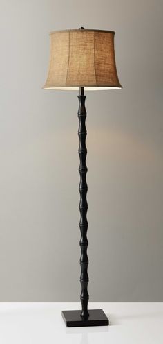 a lamp that is on top of a white table with a brown shade over it