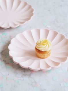 a cupcake sitting on top of a pink plate