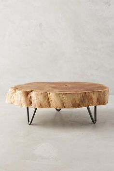 a wooden table with black metal legs and a wood slab on the top that has been turned into a coffee table