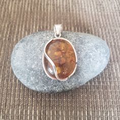 A vintage sterling silver and Baltic amber pendant featuring a simple and elegant design. The pendant is marked '925'. Baltic Amber Pendant Style: Modernist Baltic Amber Pendant Height: 4.1cm Baltic Amber Pendant Width: 2.9cm Baltic Amber Pendant Weight: 11.93g This sterling silver and Baltic amber pendant is in very good vintage condition and would be ideal for someone that enjoys wearing preloved jewelry. An eco friendly gift bag is included with the amber gemstone pendant. Free delivery worldwide. Returns accepted. Thank you for visiting our shop and please contact us if you have any questions. Amber Sterling Silver Necklaces With Cabochon, Amber Cabochon Necklaces In Sterling Silver, Amber Cabochon Necklace In Sterling Silver, Amber Sterling Silver Necklace With Cabochon, Amber Polished Oval Pendant Jewelry, Amber Oval Pendant With Polished Finish, Hallmarked Amber Oval Pendant Jewelry, Amber Sterling Silver Round Pendant Jewelry, Amber Oval Pendant Jewelry, Hallmarked