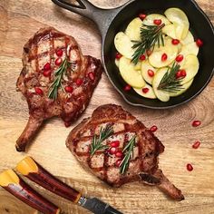 two meats in a skillet with potatoes and rosemary on the side next to them