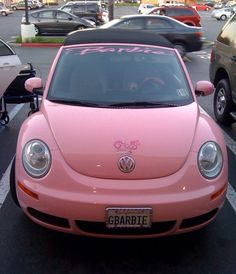 a pink car is parked in the parking lot