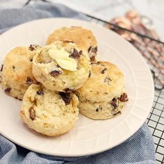 a white plate topped with cookies on top of a blue cloth next to a cooling rack