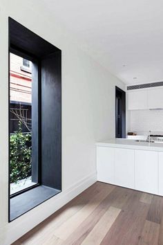 an image of a kitchen with wood floors and white cabinets in the middle of it