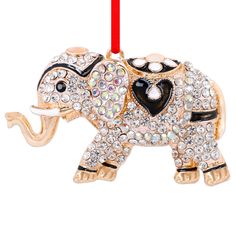 an elephant ornament hanging from a red ribbon on a white background with crystal stones