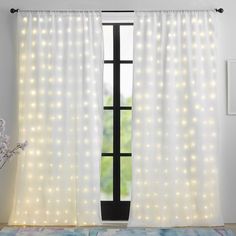 a white curtain with lights on it in front of a large window and a rug