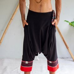 a man with no shirt wearing black and red shorts