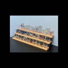 a wooden shelf filled with glasses on top of a table