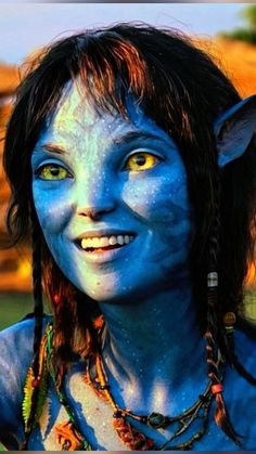 a woman with blue paint on her face and chest is smiling at the camera,