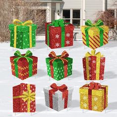 many presents are wrapped in bright colors and have bows, ribbons, and snowflakes on them