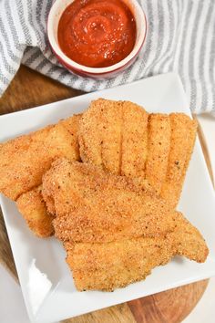 fried fish sticks on a plate with ketchup