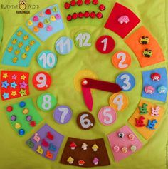 a clock made out of felt with numbers and shapes