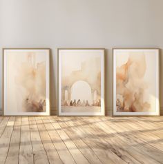 three paintings on the wall in an empty room with wood flooring and white walls