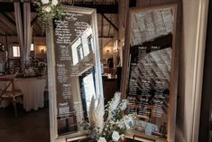 a large mirror sitting on top of a table next to a vase filled with flowers