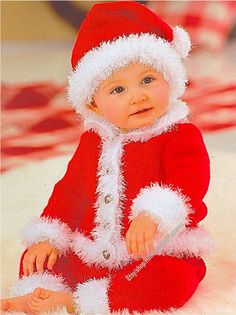 a baby in a santa suit sitting on the floor