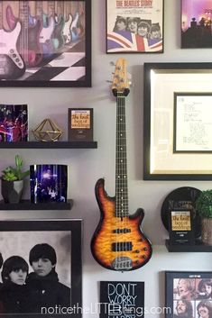 a guitar is hanging on the wall next to pictures