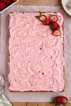 a strawberry cake with frosting and strawberries on the top is ready to be eaten