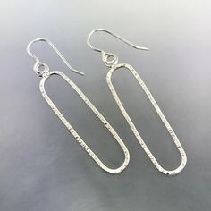 Sterling Silver line textured oval dangle earrings that measure 2 inches long and hand from Sterling Silver ear wires. They are all hand constructed by me using traditional metalsmithing techniques.  As I hand build each piece of my jewelry, I will need 7-10 days to complete your order. If you need them sooner, send me a message and I'll see if I can them done for you. Thanks so much! Jen Artisan Oval Earrings With Ear Wire, Oval Silver Wire Wrapped Earrings, Silver Oval Wire Wrapped Earrings, Handmade Oval Minimalist Earrings, Handmade Minimalist Oval Earrings, Minimalist Handmade Oval Earrings, Artisan Oval Hand Forged Earrings, Hand Forged Oval Artisan Earrings, Artisan Hand Forged Oval Earrings