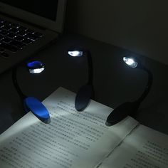 an open book sitting on top of a table next to two light up headphones