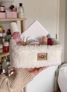 a person holding up a white case filled with cosmetics