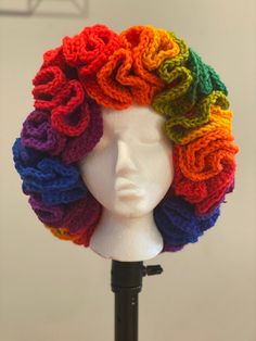 a white mannequin head with multicolored crochet hair on it