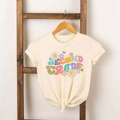 Looking for a cute tee for your kids? We have the perfect Second Grade Flowers graphic tee addition to their closet! Spring Graphic Print T-shirt For School, School Spirit Graphic Print Tops For Spring, Spring Graphic Print Top For School Spirit, Spring Graphic Tee Tops For School, Spring Slogan T-shirt For School, Spring School T-shirt With Slogan, Slogan T-shirt For School In Spring, Playful T-shirt For School In Spring, Cute Slogan Tops For School