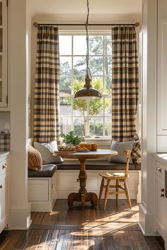 a window seat in the corner of a kitchen with a table and chairs next to it