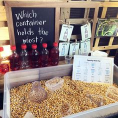 an assortment of condiments on display in a market stall, including corn and drinks