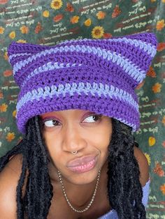 a woman wearing a crocheted hat with braids