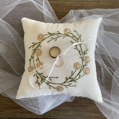 a ring pillow with embroidered flowers on it