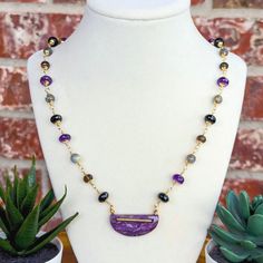 Add a truly unique piece to your jewelry collection with this exquisite handmade gemstone necklace, meticulously crafted to showcase a blended beauty of nature's finest gemstones. This piece features a harmonious blend of Amethyst, Labradorite, Black Spinel, and Smokey Quartz gemstones, each carefully wire-wrapped together to form a stunning and unique chain. Check out our full line of handmade gemstone necklaces here: https://www.etsy.com/shop/WanderlustDesignTX?section_id=40696534 Key Features Artisan Gold Amethyst Necklace, Artisan Gold Necklace With Amethyst, Artisan Amethyst Wire Wrapped Necklaces, Labradorite Necklace With Gemstone Accents For Gift, Artisan Purple Wire Wrapped Necklace, Artisan Amethyst Gemstone Beads Jewelry, Artisan Beaded Necklaces With Gemstone Accents For Gift, Unique Amethyst Gemstone Beads Necklace, One Of A Kind Amethyst Jewelry Gift