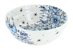 a blue and white bowl with flowers painted on the side, sitting in front of a white background