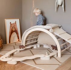 a little boy that is sitting on top of a bed in a room with toys