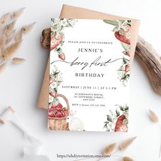 an image of a birthday party card with flowers and strawberries on the front, next to some dried plants