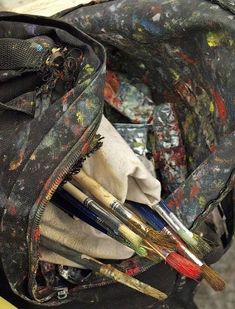 an open backpack filled with paint and brushes