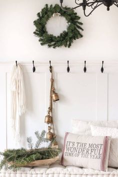 a christmas wreath hangs on the wall next to a bench with pillows and other decorations