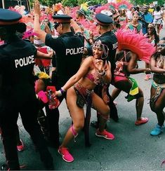 a group of people that are standing in the street with some police officers behind them