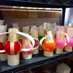 several vases are lined up on a shelf in a room with boxes and other items