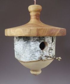 a bird house hanging from a wooden pole