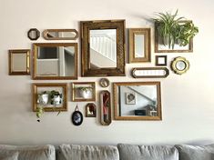 a living room wall filled with lots of framed pictures and mirrors on it's side