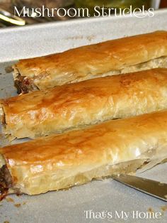 there are two long rolls on the baking pan together, one is filled with meat