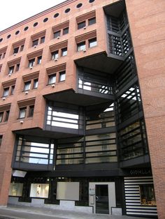 a tall building with balconies and windows on the top floor is shown in spanish