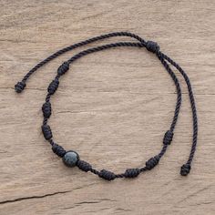 Rugged meets beautiful in this pendant bracelet designed by Ruben and Gilda Perez of Guatemala. A single bead of captivating black jade is centered on black nylon cord with evenly spaced cylindrical knots. The bracelet is easy to put on and fit to size thanks to a sliding knot closure. Black Necklace With Adjustable Cord For Meditation, Black Beaded Bracelet With Sliding Knot, Black Adjustable Braided Bracelets With Round Beads, Adjustable Black Braided Bracelet With Round Beads, Black Bohemian Bracelet With Waxed Cord, Spiritual Hand-strung Jewelry In Waxed Cord, Bohemian Black Jewelry With Sliding Knot, Adjustable Black Hand-strung Braided Bracelet, Adjustable Spiritual Obsidian Jewelry