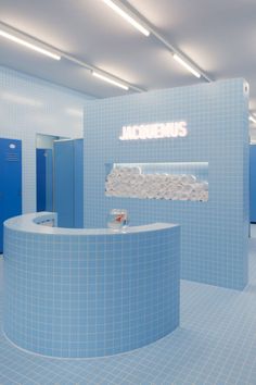 the interior of a bathroom with blue tile walls and flooring, including a circular counter