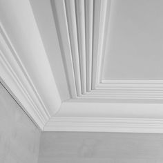 the corner of a room with white trim on the walls and ceiling is shown in black and white