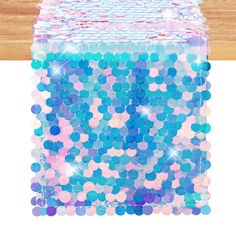 a blue and pink sequinized box on top of a wooden table